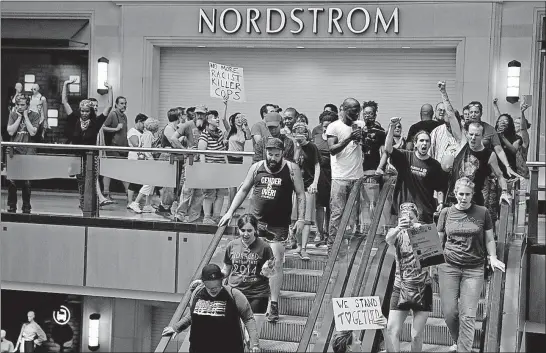  ?? [JEFF ROBERSON/THE ASSOCIATED PRESS] ?? Protesters march through the West County Mall in Des Peres, Mo., on Saturday, a day after a judge delivered a not-guilty verdict in the trial of former St. Louis police officer Jason Stockley. Stockley was accused of the 2011 killing of Anthony Lamar...