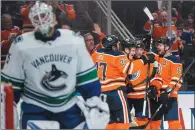  ?? CP PHOTO JASON FRANSON ?? Edmonton Oilers celebrate a goal by Jesse Puljujarvi (98) against Vancouver Canucks goalie Jacob Markstrom (25) during second period NHL action in Edmonton on Saturday.