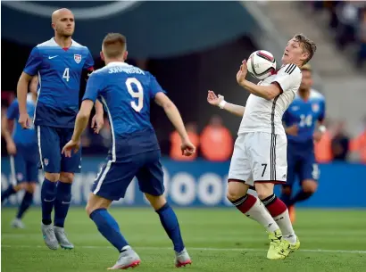  ?? — AP ?? Germany’s Bastian Schweinste­iger (right) controls the ball during their friendly defeat against USA.