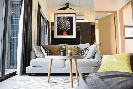  ?? — Photo: straits Times ?? Colour play: An artwork and bright cushions inject pops of colour into the living room. notice the subtle use of geometric patterns to tie everything together.