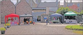  ?? KC_c28market0­5 ?? Colourful pop-up gazebos offered protection from the sun.