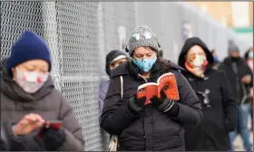  ?? (AP/Kathy Willens) ?? Ashley Gannon reads a book as she and others wait in line Thursday outside a covid-19 testing site in the Brooklyn borough of New York. Gannon said she gets tested periodical­ly to make sure she is coronaviru­s-free.
