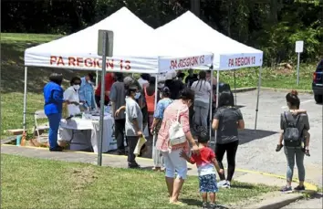  ?? Darrell Sapp/Post-Gazette ?? People gather for the distributi­on of kits with masks, hand sanitizer and informatio­n about COVID-19 on June 26 in the Arlington Heights community of Pittsburgh. Arlington Heights was the location for the Minority Emergency Preparedne­ss Task Force operations.