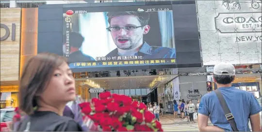  ?? Steven Camley is away ?? WHEREABOUT­S UNKNOWN: Footage of US whistleblo­wer Edward Snowden is displayed on a giant screen in a televised news programme in Hong Kong.