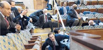  ?? ANDREW HARNIK/AP ?? People shelter in the House gallery as protesters try to break into the House Chamber on Wednesday at the Capitol in Washington, D.C.. U.S. Rep. Jim Himes can be seen at left.