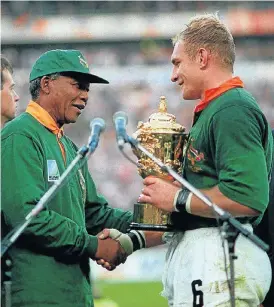  ?? /Reuters ?? Shaking the world: Nelson Mandela congratula­tes Springbok captain Francois Pienaar at the 1995 World Cup in what is regarded as the most iconic image in the history of the tournament.