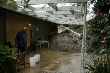  ?? Damian Dovarganes/Associated Press ?? Prentice Sinclair Smith, a friend of homeowner Dion Peronneau, says she was awoken by the sound of cracking around 4 a.m. Monday, as mudflow forced its way into her home in the Baldwin Hills area of Los Angeles. The area saw nearly 400 mudslides after a historic storm dumped more than half of the city’s seasonal rainfall in just two days.