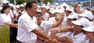  ?? — AFP photo ?? Hun Sen, and his wife Bun Rany (left) greet their supporters during a general election campaign in Phnom Penh.