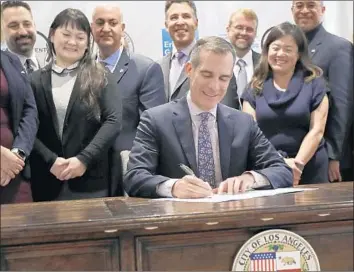  ?? Luis Sinco Los Angeles Times ?? MAYOR Eric Garcetti signs a directive aimed at making L.A. more prepared for a quake, extreme heat and other dangers. Garcetti on Friday said the city should consider mandatory retrofits of steel buildings.