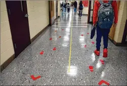  ?? JESSICA HILL/ ASSOCIATED PRESS ?? Students stay distanced and in separate lanes between classes this week at Windsor Locks High School in Connecticu­t. New evidence indicates it may be safe for schools to keep students only 3 feet apart.