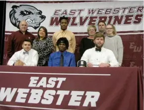  ?? P. Smith, SDN) (Photo by Danny ?? East Webster football players Conner Goodin, seated from left, Isaac Patterson and Cole Morgan celebrate their signing at the junior colleges on Wednesday morning with their families. Patterson and Gordon will be attending East Central Community...