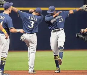  ?? KIM KLEMENT / USA TODAY SPORTS ?? Center fielder Keon Broxton and shortstop Orlando Arcia celebrate Friday night after the Brewers beat the Rays, 2-0, at Tropicana Field in St. Petersburg, Fla.