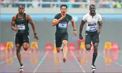  ?? ALY SONG / REUTERS ?? China’s Su Bingtian, flanked by Britain’s Chijindu Ujah and American Justin Gatlin, powers to a second-place finish in the men’s 100m final at the 2018 IAAF Diamond League meet at Shanghai Stadium on Saturday.