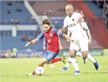  ??  ?? Johor Darul Takzim (JDT) player Muhammad Nazmi Faiz is tackled by Kashima Antlers player Hugo Leonardo Serejo during the Asia Champions League (ACL) match at Tan Sri Hassan Yunus Larkin Stadium in Johor Bharu on Wednesday night.