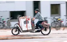  ?? FOTO: DPA ?? Mit einem E-Lastenrad lässt sich auch schwere Ladung wie eine Waschmasch­ine transporti­eren.