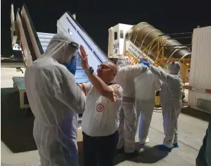  ?? (MDA) ?? MAGEN DAVID ADOM teams prepare to evacuate Israeli passengers arriving from South Korea yesterday to home isolation.