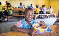  ??  ?? Vital aid A boy in Liberia receiving food through Mary’s Meals