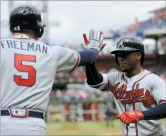  ?? MICHAEL PEREZ THE ASSOCIATED PRESS ?? Ozzie Albies, right, set the tone early for the Atlanta Braves when he blasted the first pitch of the game for a solo home run. Not much went right for the Phillies after that as the Braves rolled to a 10-1 victory Sunday afternoon at Citizens Bank Park.