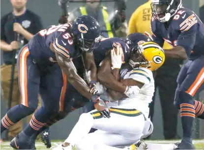  ??  ?? Packers receiver Davante Adams goes down unconsciou­s just after a vicious helmet- to- helmet hit by the Bears’ Danny Trevathan ( left) on Thursday night. Trevathan was apologetic after the game but still said he thought he hit Adams high in the...