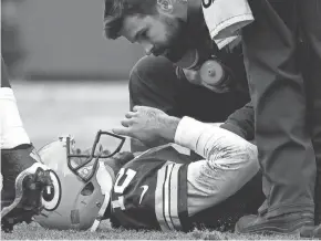  ?? RICK WOOD / MILWAUKEE JOURNAL SENTINEL ?? Green Bay Packers quarterbac­k Aaron Rodgers is attended to after suffering a “stinger” in Saturday’s game against the Minnesota Vikings. Rodgers shook it off and returned to the field.