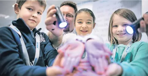  ?? RP-FOTO: RALPH MATZERATH ?? Maximilian, Candela und Paula zeigen ihre gewaschene­n Hände im UV-Licht.