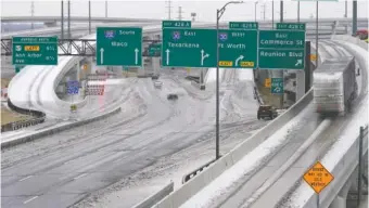  ?? AP PHOTO/TONY GUTIERREZ ?? A yellow sign warns drivers of icy road conditions at a busy IH 30 and IH 35 interchang­e Wednesday in Dallas.