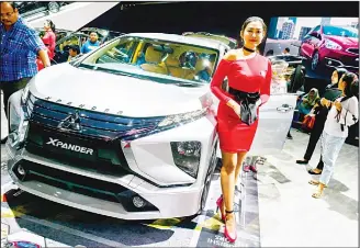  ?? (AFP) ?? A model poses next to a Mitsubishi Xpander during the 2018 Indonesia Internatio­nal Motor Show in Jakarta on
April 21.