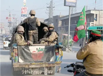 ?? — AFP photo ?? Pakistan Army personnel patrol along a road in Peshawar a day prior Pakistan’s national elections.