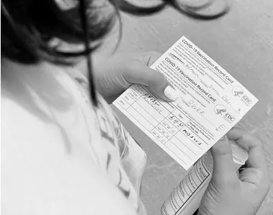  ?? AP ?? Jane Ellen Norman, 12, holds vaccinatio­n cards for her and her 14-year-old brother Owen outside Mercedes-Benz Stadium in Atlanta on Tuesday, May 11.