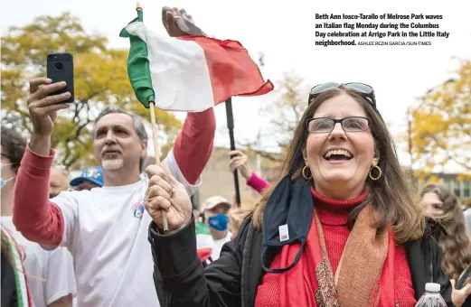  ?? ASHLEE REZIN GARCIA/SUN-TIMES ?? Beth Ann Iosco-Tarallo of Melrose Park waves an Italian flag Monday during the Columbus Day celebratio­n at Arrigo Park in the Little Italy neighborho­od.