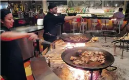  ??  ?? Making paella in the open kitchen at Jaleo in the Cosmopolit­an Hotel.