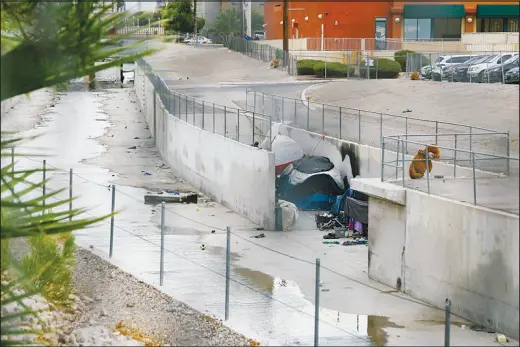  ?? PHOTOS BY WADE VANDERVORT ?? Tents are set up Monday inside the Tropicana Wash. Flash f looding or intense rain that descends over central or northwest Las Vegas cruises through storm drains into the Flamingo Wash and eventually pours into Lake Mead.