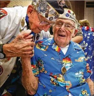  ?? HOWARD LIPIN / SAN DIEGO UNION-TRIBUNE ?? Stuart Hedley (left), 98, president of the San Diego Chapter of the Pearl Harbor Survivors Associatio­n, and fellow member Clayton Schenkelbe­rg, 101, greet one another Sept. 21 in La Mesa, California, before the chapter’s birthday luncheon and the final official board meeting of the group before it was discontinu­ed.