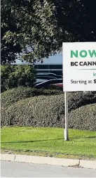  ??  ?? In this September 26, 2018 photo, a pedestrian walks past a sign advertisin­g jobs with BC Cannabis Operations in front of the warehouse in Richmond, British Columbia, that will store marijuana purchased from licensed producers before it is shipped to retail shops and online customers.