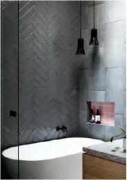  ??  ?? Black pendants and ‘Liquid Glass’ subway tiles from Perini Tiles create mood in this Melbourne bathroom.