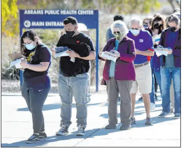  ?? Kelly Presnell The Associated Press ?? Hundreds of people fill out paperwork Tuesday while waiting to get free COVID test kits at the Abrams Public Health Center in Tucson, Ariz.