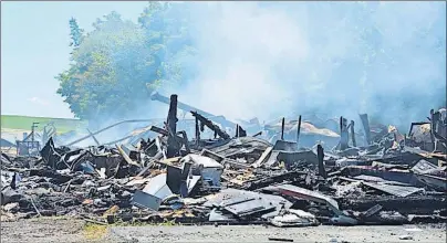  ?? ©NIKKI SULLIVAN/CAPE BRETON POST ?? The office and store at Eyking Farms burned to the ground early Sunday morning and smoke still billowed from the site hours after firefighte­rs left, while crews began the cleanup.