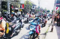  ?? — ROBIN ESROCK ?? Heavy traffic in Ubud clogs roads in the uplands of Bali, where tourists’ garbage litters beaches.