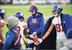  ?? Gail Burton / Associated Press ?? Giants offensive coordinato­r Jason Garrett, center, greets players on the sideline after a touchdown against the Ravens on Sunday.