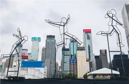  ?? Photo: Jelly Tse ?? Big artwork figures seem to be jumping for joy against the Wan Chai skyline.