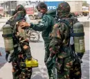  ?? — PTI, AFP ?? School students (left) being treated at a hospital in New Delhi on Saturday after gas leakage from a container depot. Members of the National Disaster Response Force prepare to take part in a clean-up operation at the depot.