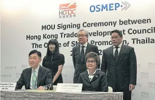  ??  ?? Deputy Prime Minister Somkid Jatusripit­ak (centre) and Industry Minister Uttama Savanayana (standing right) attend the MoU signing ceremony between the Hong Kong Trade Developmen­t Council and the Office of SME Promotion.