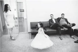  ??  ?? Penelope Mercado, 3, spins in her dress while waiting for her mom, Carmen Mercado, and stepdad Miguel Magdeleno (center) to get married. Jose Santiago (right) was a groomsman.