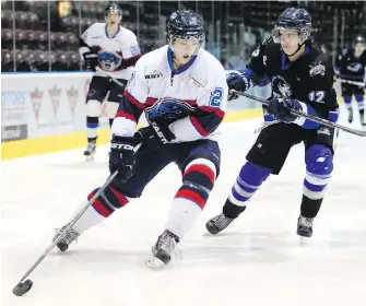  ??  ?? Panthers defenceman Mitch Maloney tries to fend off Wolves forward Brandon Tutte during VIJHL action Wednesday at The Q Centre. The Panthers won 7-4.