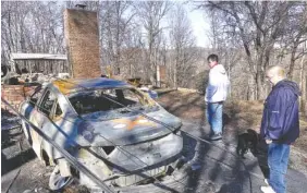 ?? ASSOCIATED PRESS FILE PHOTO ?? Charlotte Moore, right, and her neighbor, Morgan Wallace, look at what remains of Moore’s car in the Roaring Fork neighborho­od of Gatlinburg, Tenn., last December.