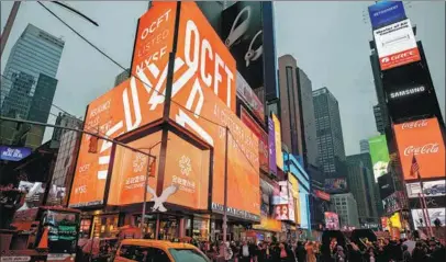  ?? PROVIDED TO CHINA DAILY ?? Pedestrian­s walk through the Times Square while a digital advertisem­ent of OneConnect appears on giant screens in New York.