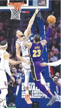  ?? BILL STREICHER-USA TODAY SPORTS ?? PHILADELPH­IA 76ERS guard Ben Simmons blocks a shot attempt by Los Angeles Lakers forward LeBron James during the fourth quarter at the Wells Fargo Center.