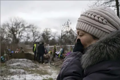  ?? EVGENIY MALOLETKA — THE ASSOCIATED PRESS FILE ?? Tamila Pyhyda cries during the exhumation of her husband Serhii Pyhyda who was killed by Russian forces in the recently retaken town of Vysokopill­ya, Ukraine, Monday, Dec. 5, 2022. Russian invaders left behind all sorts of trickery as they fled the southern city to jubilation across Ukraine a month ago, and continue to strike it from afar. Life in Kherson is still far from back to normal.