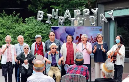  ?? ?? People take part in a birthday celebratio­n at an old-age community