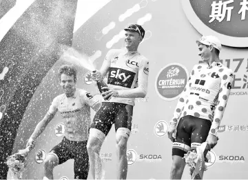  ??  ?? Chris Froome of Britain (C) celebrates winning the Tour de France China Criterium as Rigoberto Uran of Colombia (L) and France’s Warren Barguil (R) look on in Shanghai on October 29, 2017.Tour de France winner Chris Froome won the contest, which is a...